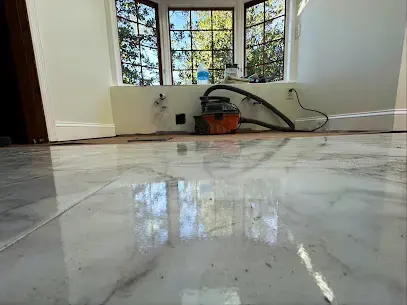 Wet marble floor being vacuumed in an Elsmere home