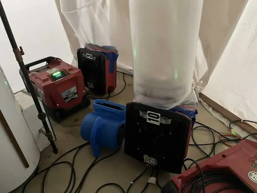 Dehumidifiers and air movers running inside plastic containment